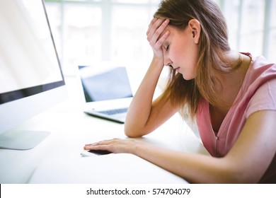 Tired female graphic designer at desk in creative office - Powered by Shutterstock