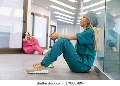 Tired Female Medical Professional Taking Break in Hospital Corridor  - Powered by Shutterstock