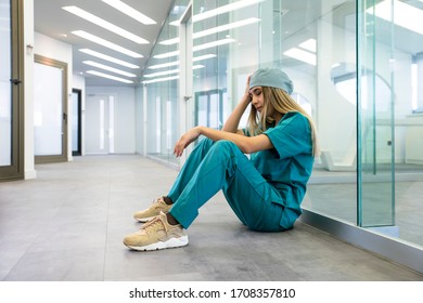 Tired Female Medical Professional Taking Break in Hospital Corridor  - Powered by Shutterstock