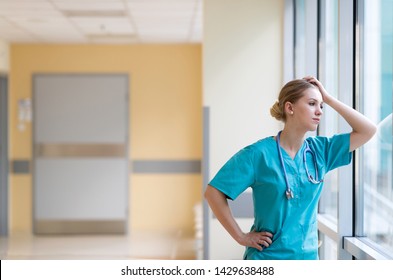Tired Female Nurse In Hospital Corridor