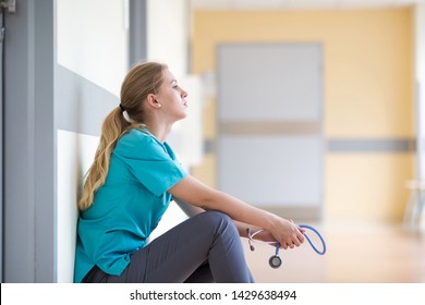 Tired Female Nurse In Hospital Corridor