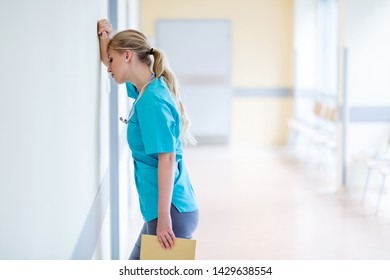 Tired Female Nurse In Hospital Corridor