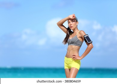 Tired Female Runner Sweating After Cardio Exercise. Asian Running Woman Sweating Post Workout Swiping Head Exhausted Or Touching Forehead Because Of Headache. Heat Exhaustion / Dehydration Concept.