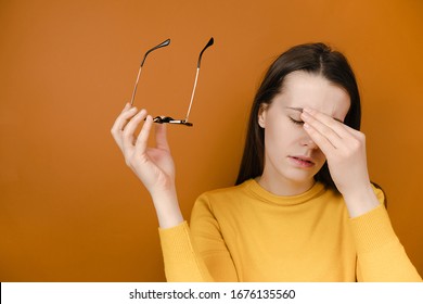 Tired Female Taking Off Glasses Tired Massaging Touching Nose Bridge, Exhausted Girl Suffering From Headache, Feeling Pain, Calming Down, Stress Relief Concept, Isolated On Orange Background
