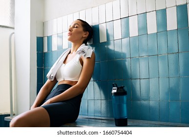 Tired fit woman with a towel in the locker room after hard workout. Stress, sport, failure concept                       - Powered by Shutterstock