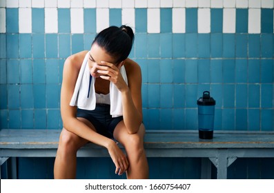 Tired fit woman with a towel in the locker room after hard workout. Stress, sport, failure concept                       - Powered by Shutterstock