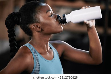 Tired, fitness or black woman drinking water in gym after training, workout or exercise to relax or hydrate body. Fatigue, fitness or girl with bottle for healthy liquid hydration on resting break - Powered by Shutterstock