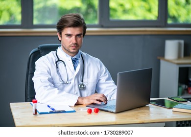 Tired And Focused Doctor Working Hard At His Laboratory Or Desk, Collecting Data And Analyzing Some Blood Test