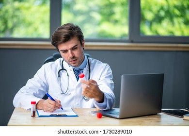 Tired And Focused Doctor Working Hard At His Laboratory Or Desk, Collecting Data And Analyzing Some Blood Test