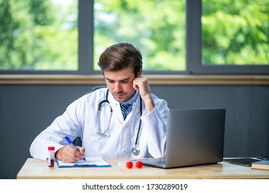 Tired And Focused Doctor Working Hard At His Laboratory Or Desk, Collecting Data And Analyzing Some Blood Test