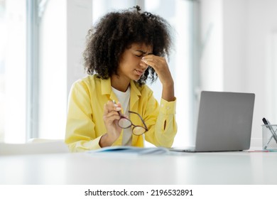 Tired Frustrated Black Woman Working In The Office, Sitting At The Table And Using A Laptop Computer