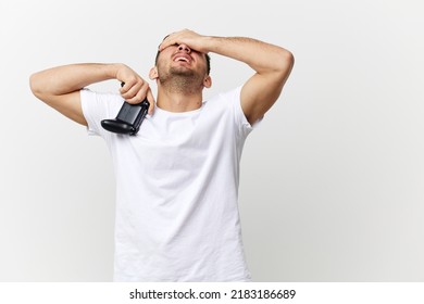 Tired frustrated sad tanned handsome man in basic t-shirt lose game session touch face with joystick gamepad posing isolated on white studio background. Copy space Banner Mockup. Gamer RPG concept - Powered by Shutterstock