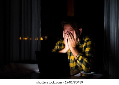 Tired and frustration man working and using laptop at late night. Businessman upset to have work too much overtime.  Stressed businessman person at home.
