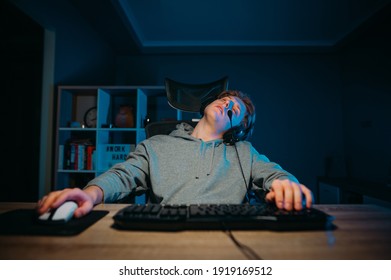 Tired Gamer Sits At Home At The Computer And Sleeps. Dream Interpretation Young Man Fell Asleep While Playing On The Computer.