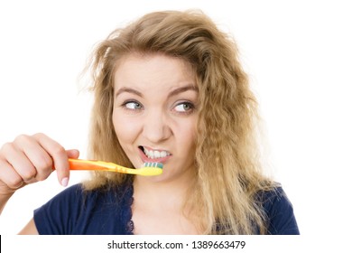 Tired Grumpy And Sleepy Blonde Woman Brushing Teeth Having Crazy Tangled Hair. Oral Hygiene Concept, Isolated Background.