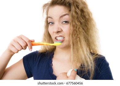 Tired Grumpy And Sleepy Blonde Woman Brushing Teeth Having Crazy Tangled Hair. Oral Hygiene Concept, Isolated Background.