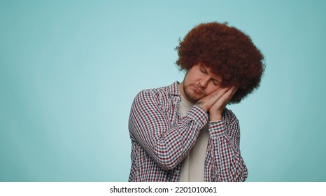 Tired Handsome Bearded Man With Lush Hair Coiffure Yawning, Sleepy Inattentive Feeling Somnolent Lazy Bored Gaping Suffering From Lack Of Sleep. Young Guy Boy Isolated Alone On Blue Studio Background