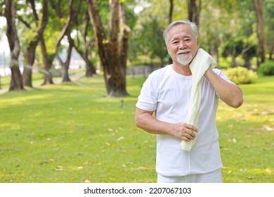 Tired Heat And Hot Asian Senior Man Practice Yoga Excercise, Tai Chi Tranining And Stretching While Wipe The Sweat Away For Healthy In Park Outdoor.  Happy Elderly Outdoor Lifestyle Concept