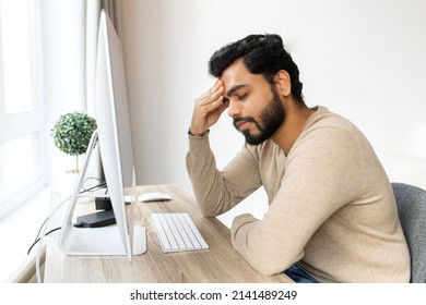 Tired Hindu Male Entrepreneur Feel Eye Strain From Online Work With Laptop, Indian Man Sits At The Table And Massaging Eyes, Feels Headache And Lack Of Energy