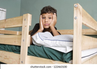 Tired Little Boy Lying On Bunk Bed