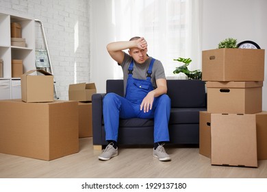 Tired Loader Sitting On Sofa In Room 
After Hard Moving Day