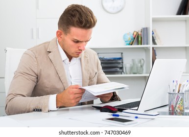 tired male admin in crisis doing paperwork at office