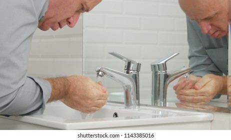 Tired Man in Bathroom Washing His Face with Fresh Water from Sink Faucet - Shutterstock ID 1143385016