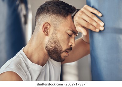 Tired man, boxer and rest with punching bag for self defense training, practice or martial arts at gym. Exhausted male person or fighter in fitness for break after intense exercise or boxing match - Powered by Shutterstock