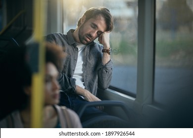 Tired man leaning on a window and sleeping while commuting by bus. Copy space. - Powered by Shutterstock