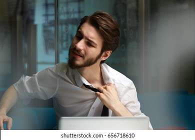 Tired man relieving his tie during late work in office