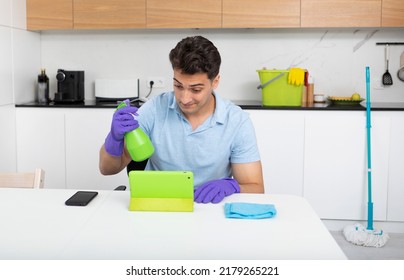 Tired Man Sitting In The Kitchen And Resting After Exhausted Cleaning House