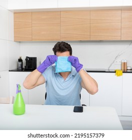 Tired Man Sitting In The Kitchen And Resting After Exhausted Cleaning House