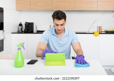 Tired Man Sitting In The Kitchen And Resting After Exhausted Cleaning House