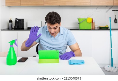 Tired Man Sitting In The Kitchen And Resting After Exhausted Cleaning House	