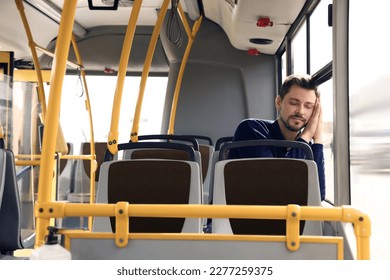 Tired man sleeping while sitting in public transport - Powered by Shutterstock