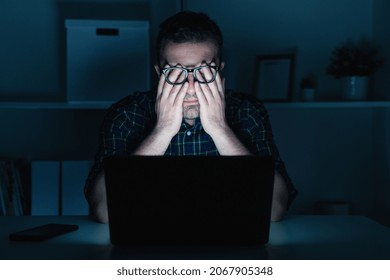 Tired man working on computer laptop late at night - Powered by Shutterstock