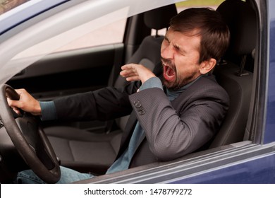 Tired Man Yawning While Driving His Car 