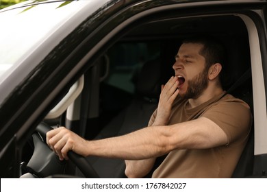 Tired Man Yawning While Driving His Modern Car