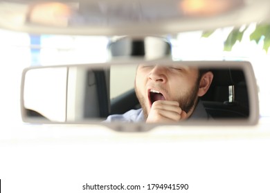 Tired Man Yawning While Driving, Reflection In Rearview Mirror