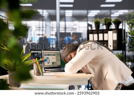 Tired manager falling asleep at computer desk while evaluating company performance by analyzing data metrics. Exhausted businesswoman dozing off while overseeing administrative operations