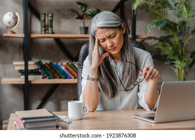 Tired mature caucasian woman having headache after hard work in office - Powered by Shutterstock