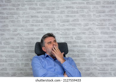 Tired Mature Male Worker Yawn Stretch In Office Chair Overwhelmed With Work At Workplace, Exhausted Biracial Man Employee Sign Feel Fatigue After Long Day, Having Sleep Deprivation. Copy Space.