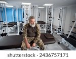 Tired military man sitting in the gym of a rehabilitation center
