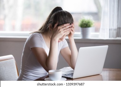Tired millennial woman sitting at laptop working at home. Overworked, stressed, sad, upset female having problems with work. Bad news, dismissal notice, head ache. Remote job, online business concept - Shutterstock ID 1339397687