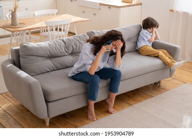 Tired Mom Complain On Little Stubborn Son Misconduct On Phone Call To Dad. Exhausted Young Mom Depressed Powerless After Quarrel Family Fight With Little Kid Talk On Mobile With Offended Boy Nearby