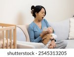 Tired mom feeding her newborn baby with milk bottle