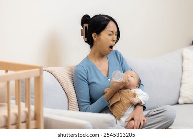 Tired mom feeding her newborn baby with milk bottle - Powered by Shutterstock