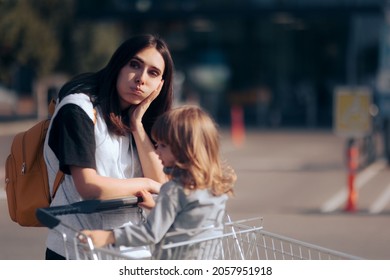 Tired Mom Shopping With Her Daughter Pushing A Supermarket Cart. Broke Family Thinking About Buying From Grocery Store
