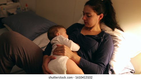 Tired mother laid in bed with baby infant at night. Authentic real life exhausted parent taking rest with toddler child - Shutterstock ID 1610413102