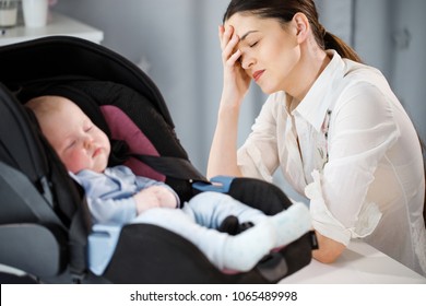 Tired Mother Is Sad Near A Sleeping Child